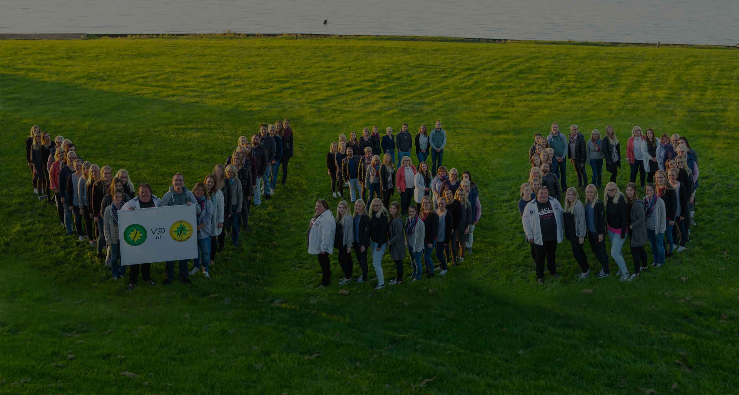 Das Team des VSD steht auf einer Wiese und bildet die Buchstaben VSD.